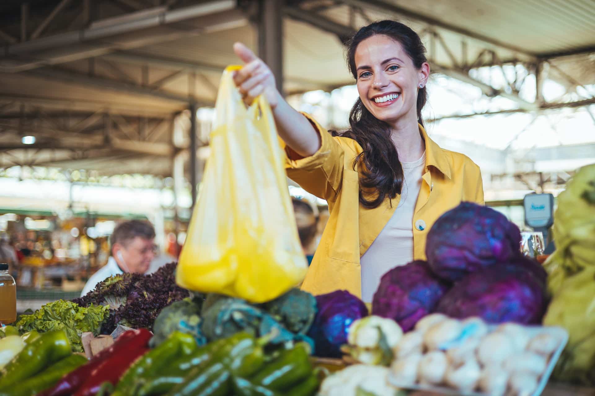 Lächelnde Frau kauft frisches Gemüse auf dem Wochenmarkt | Franz Keller Weingut